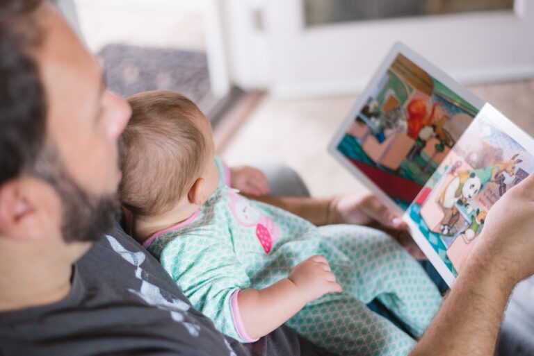 Un padre legge un libro a un neonato